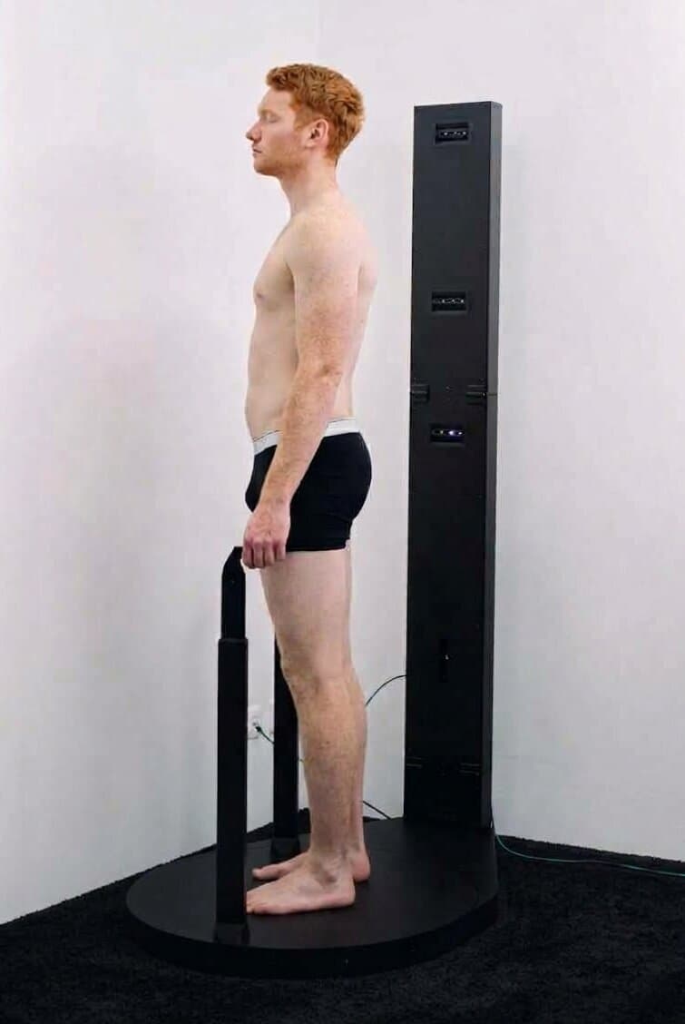 Person steht beim 3D-Körperscan auf der Scanner-Plattform