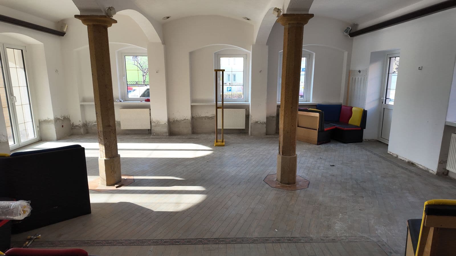 Heller Altbau-Raum mit Sandsteinsäulen und Fenstern zur Straße